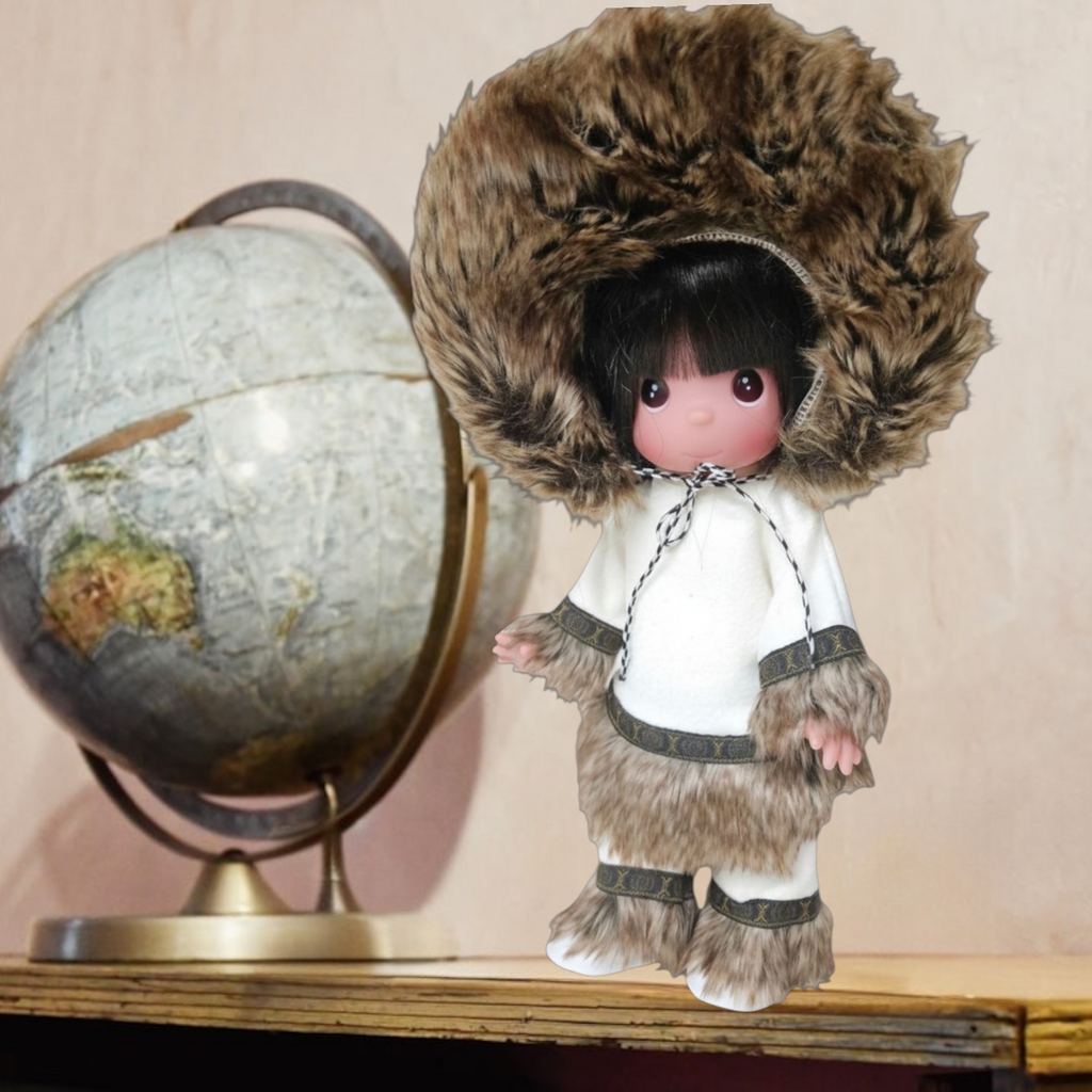 The Doll Maker 12-inch Eskimo doll wearing a white tunic and trousers with faux fur trim and a large fur-lined hood.