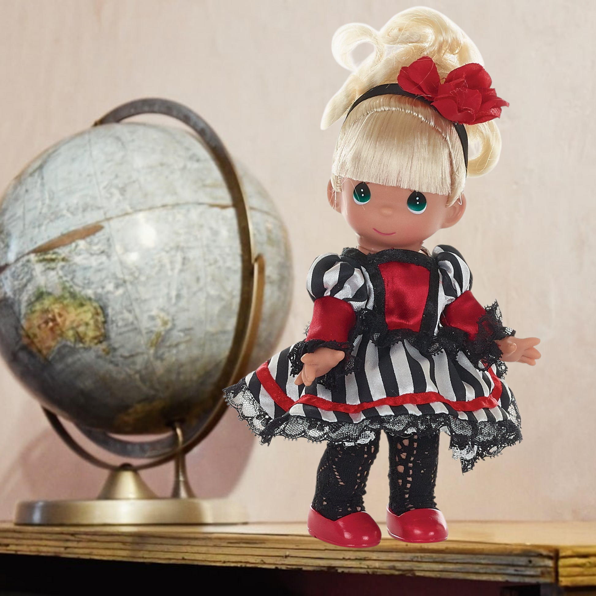 The Doll Maker 12-inch French-inspired collectible doll wearing a striped dress with red accents and a hair bow.