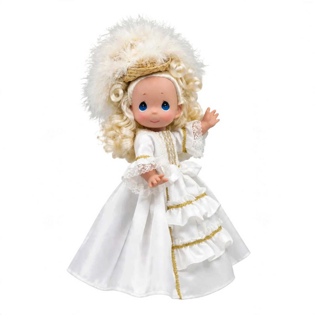 The Doll Maker 12-inch French-inspired doll wearing a white dress with gold trim and an elegant feathered hat