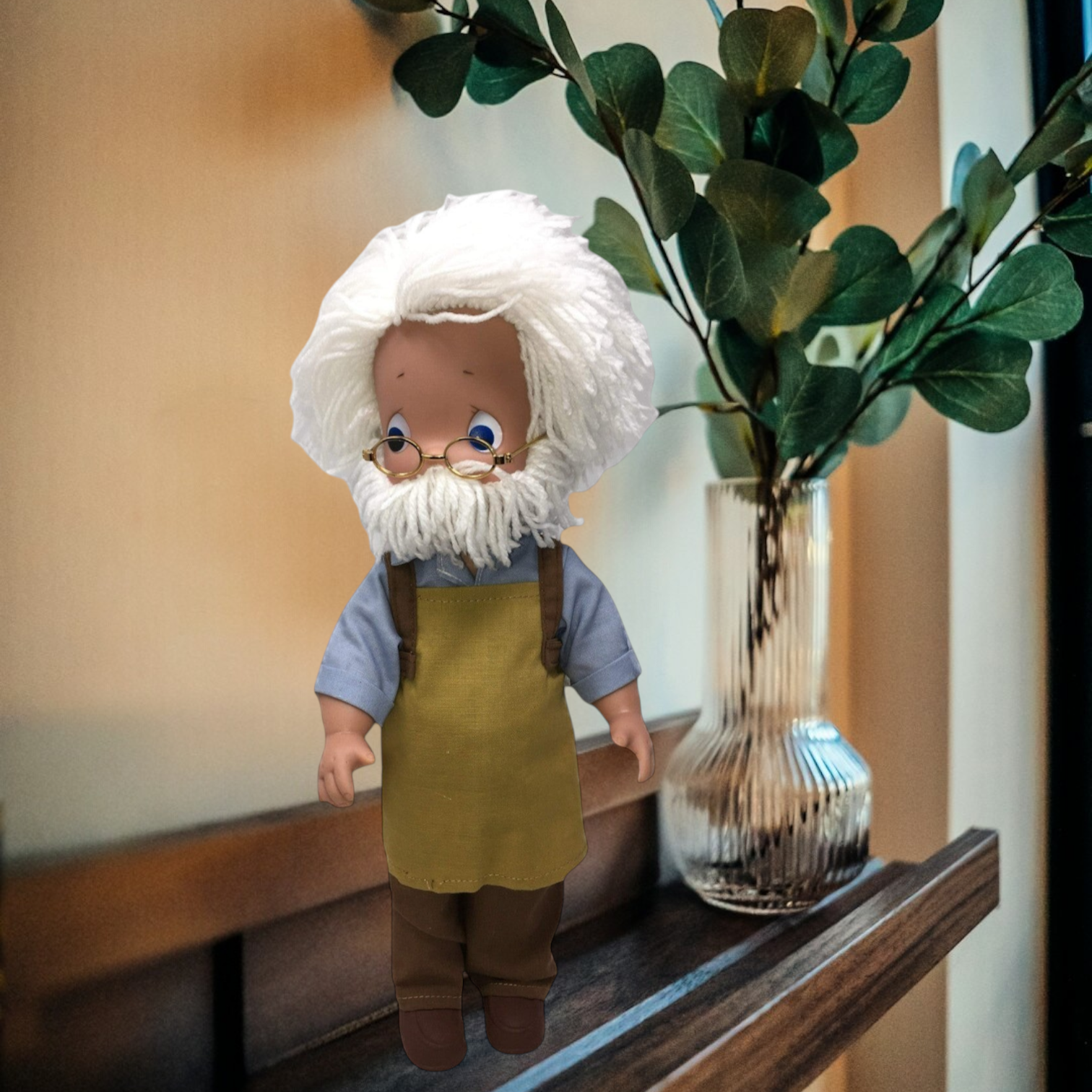 The Doll Maker 12-inch Geppetto collectible doll with white hair, wire glasses, blue shirt, and brown apron.