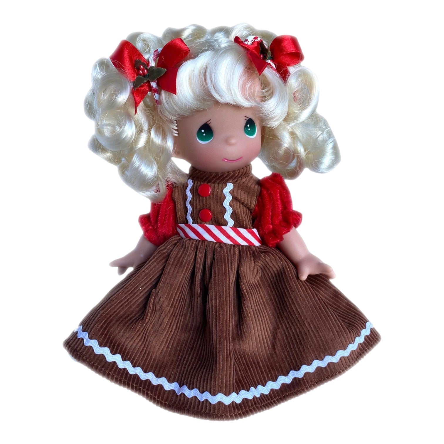The Doll Maker Precious Moments Gingerbread Girl vinyl doll with blonde curls, red bows, and a brown corduroy dress.