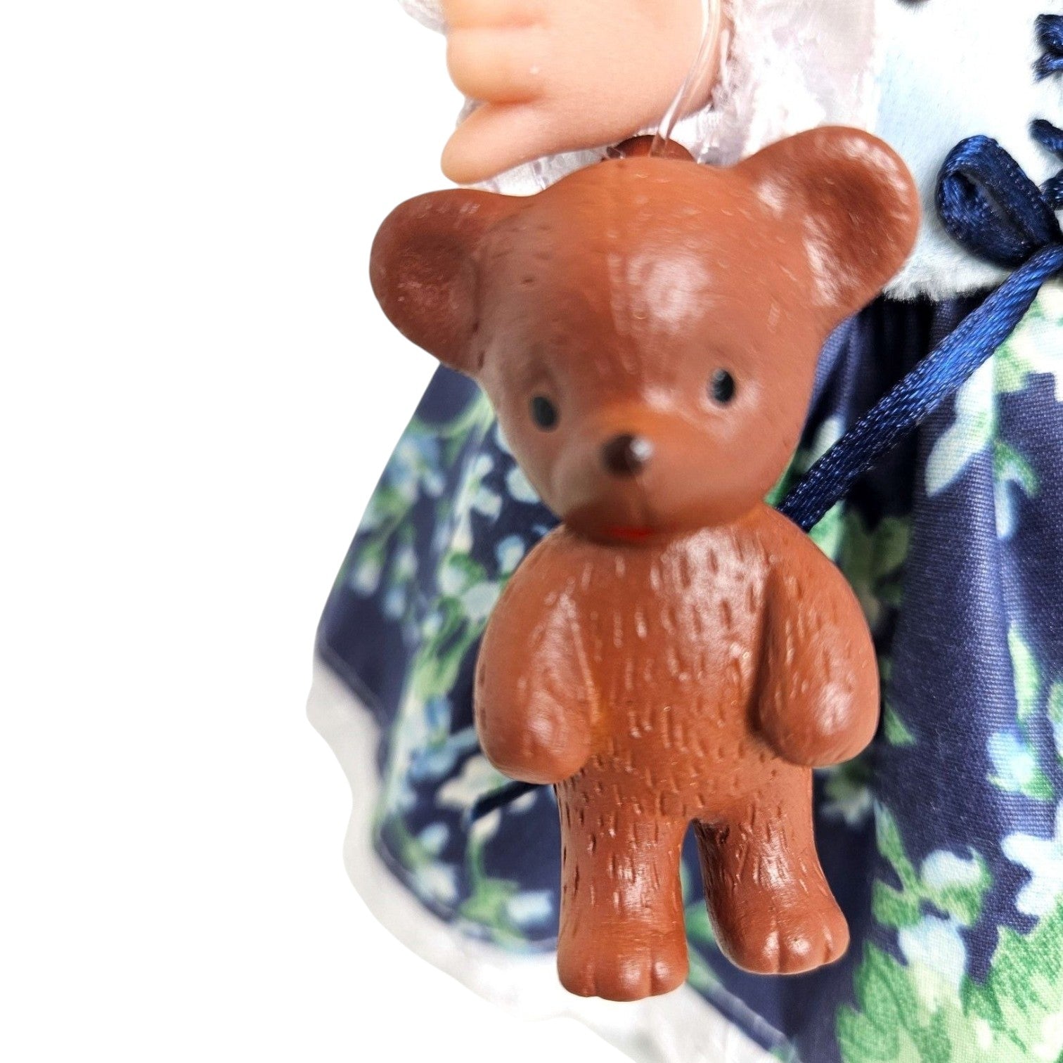 The Doll Maker Goldilocks doll holding a small brown vinyl teddy bear in a floral dress
