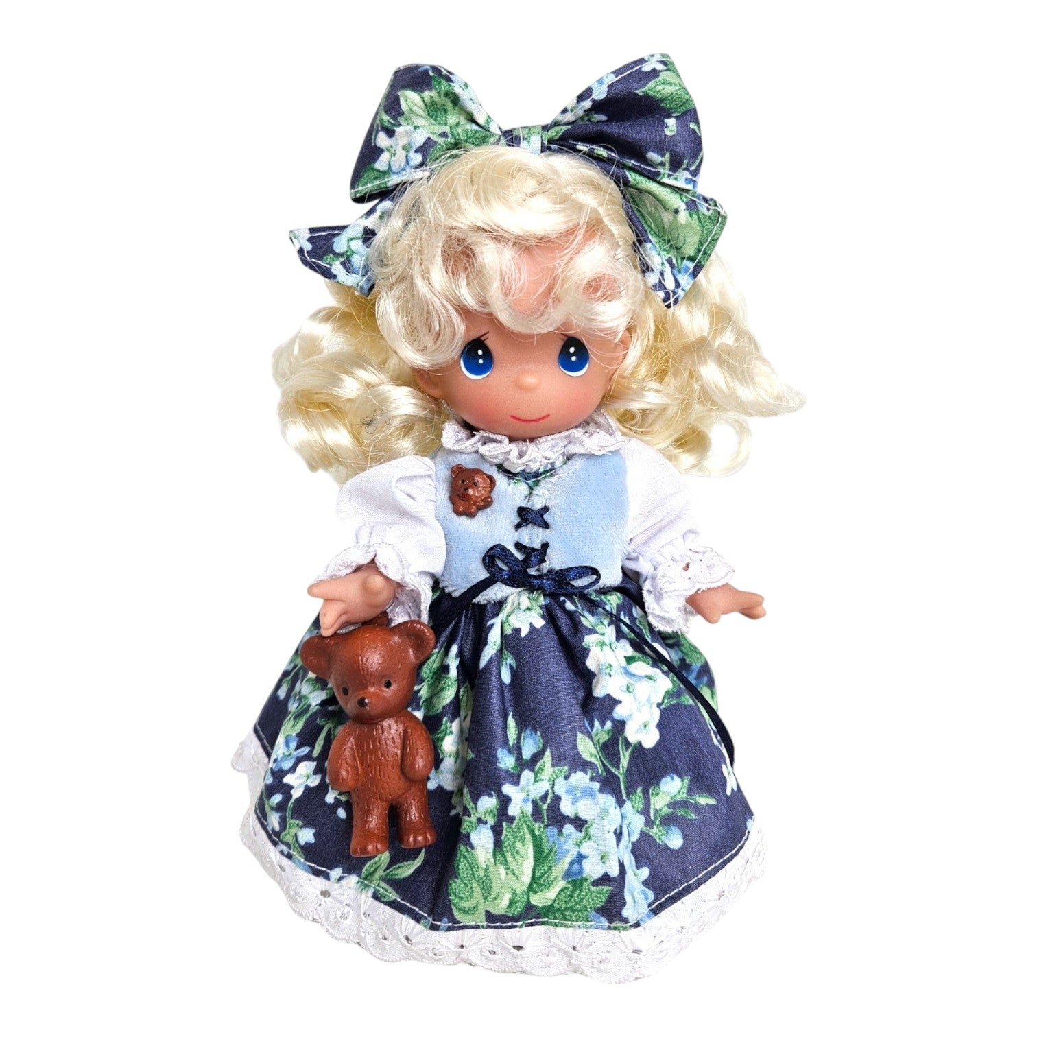The Doll Maker Goldilocks vinyl doll with blonde hair, blue dress, floral apron, and a small teddy bear accessory.