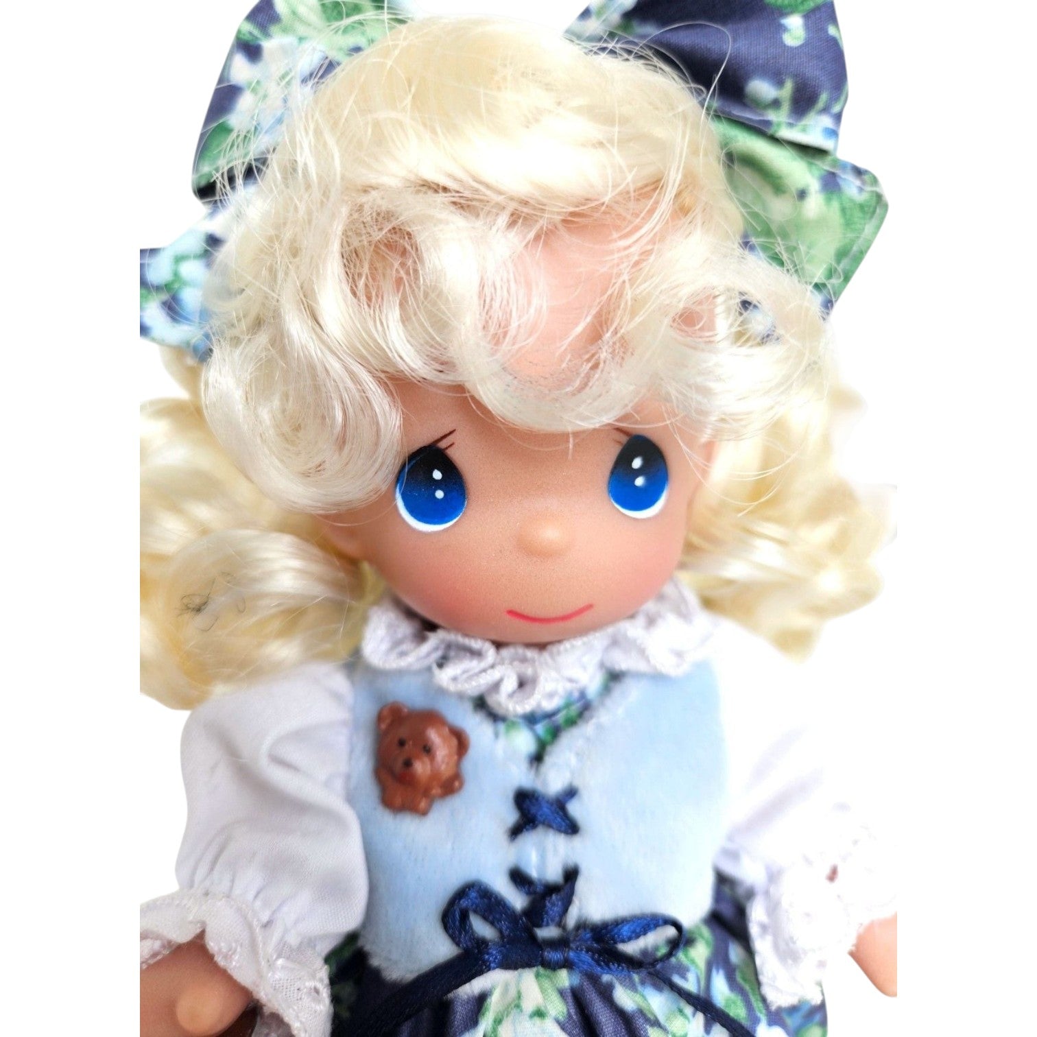 The Doll Maker 7-inch Goldilocks vinyl doll with blonde hair, blue eyes, and a blue dress holding a small bear.