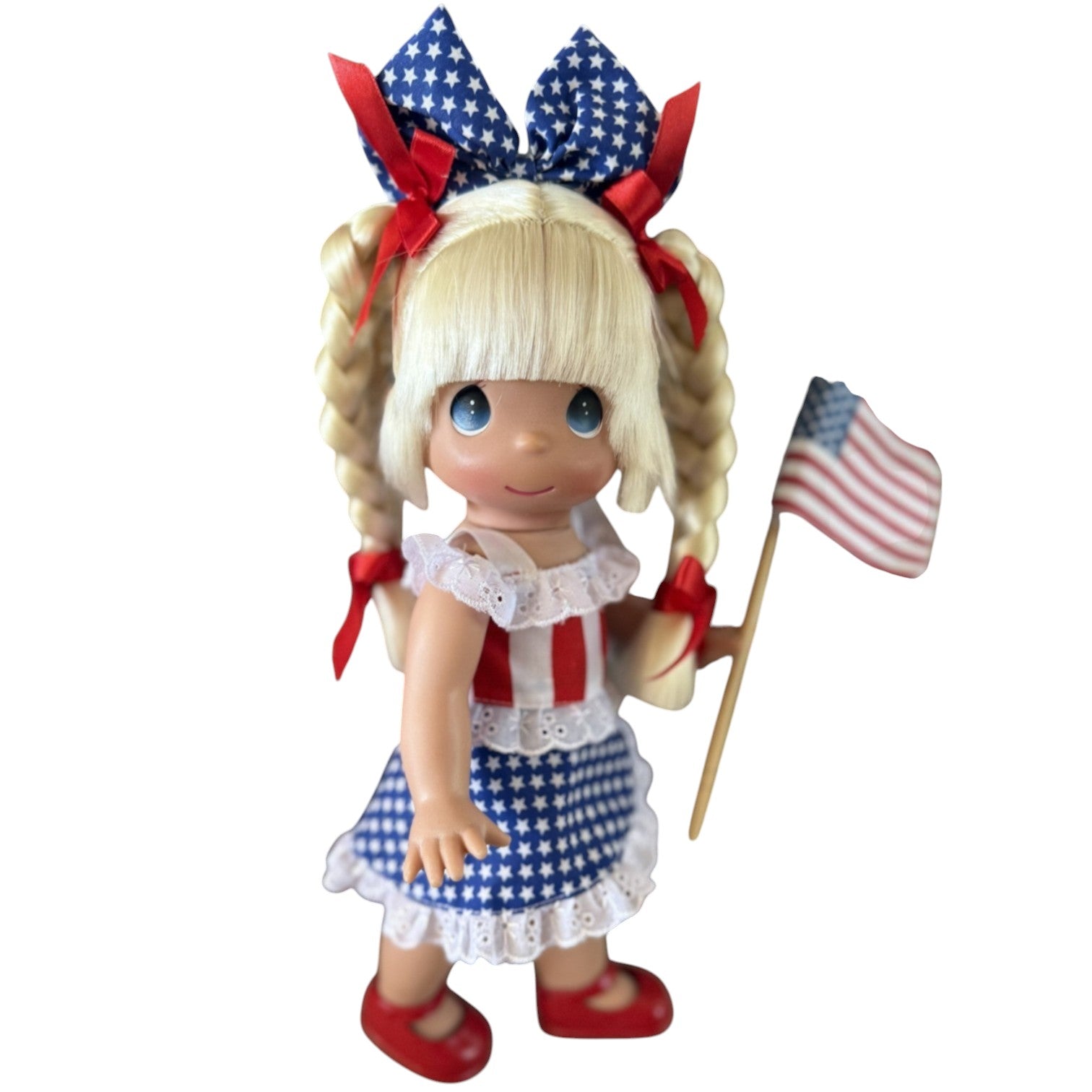 The Doll Maker 12-inch Happy Birthday America doll with blonde braids, wearing a patriotic red, white, and blue dress.
