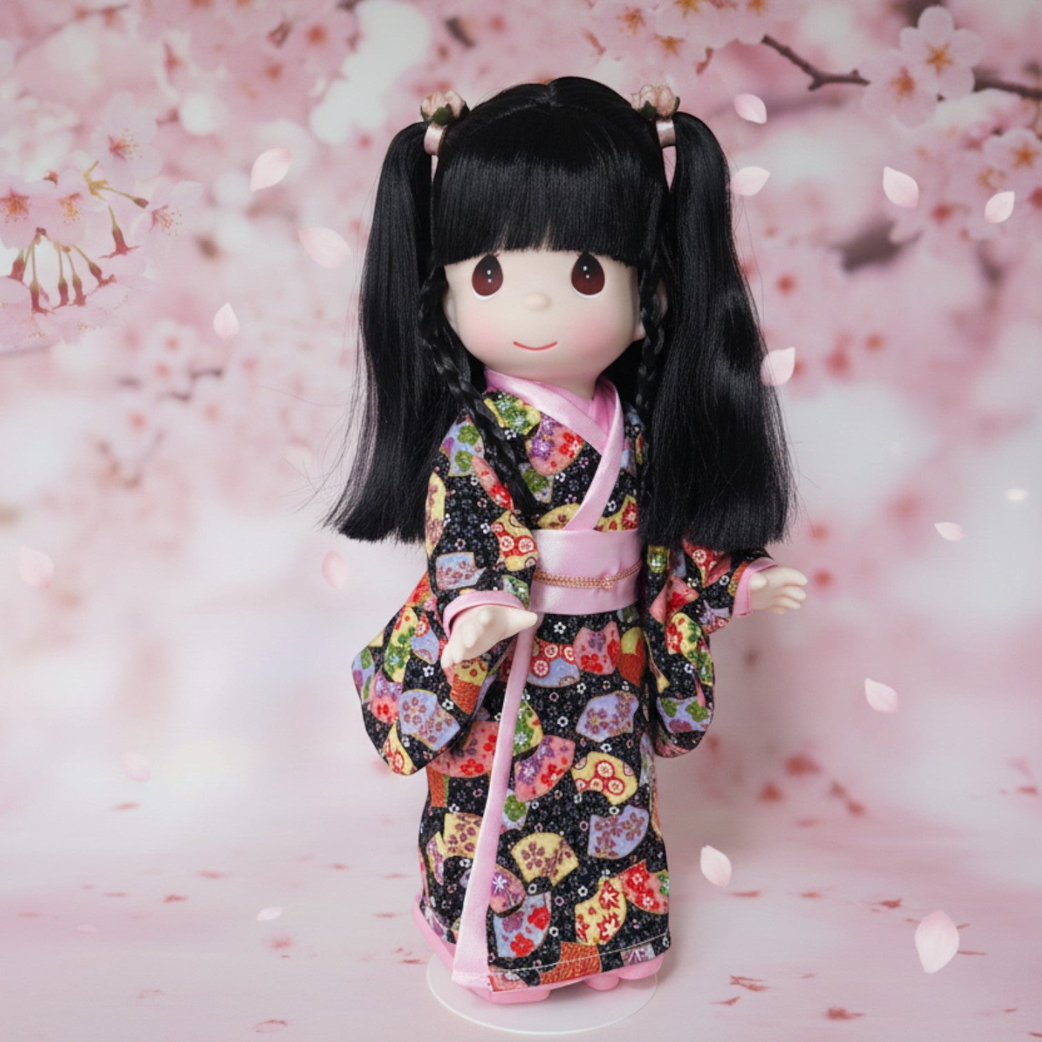 The Doll Maker Haruka doll with black hair wearing a patterned kimono, standing before a cherry blossom background.
