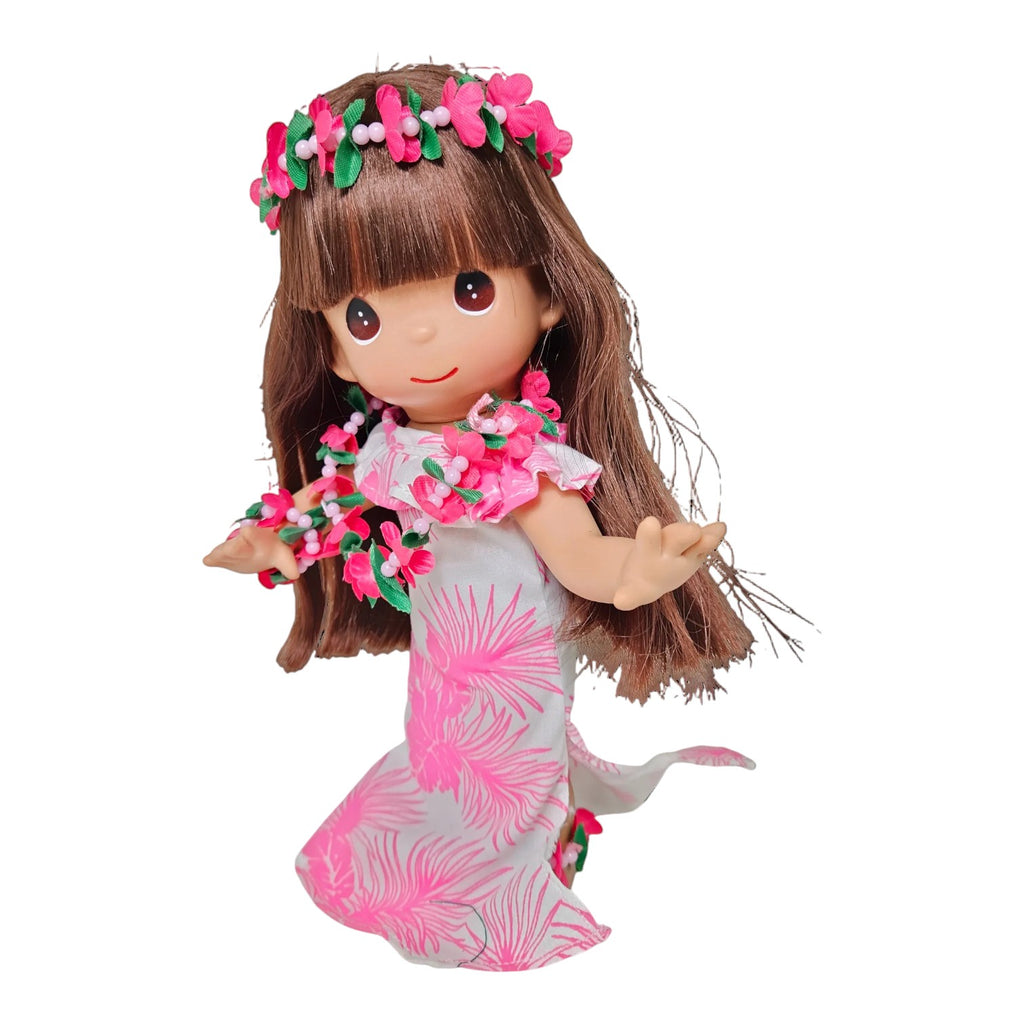 The Doll Maker Hawaii Noelani 9-inch doll wearing a white and pink tropical print dress with a floral lei and headband.
