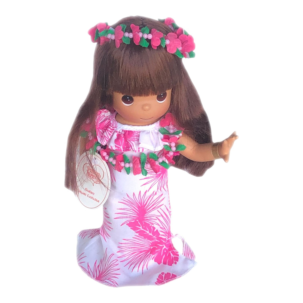 The Doll Maker Hawaii Noelani 9-inch doll wearing a white and pink tropical leaf print dress with a floral lei