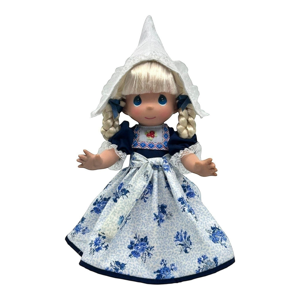 The Doll Maker 12-inch Holland doll in traditional Dutch costume with a white lace bonnet and blue floral dress.