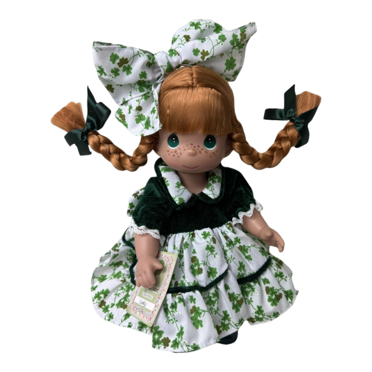 The Doll Maker 12-inch Ireland doll with red braided hair, green velvet dress, and white shamrock print apron and bow.