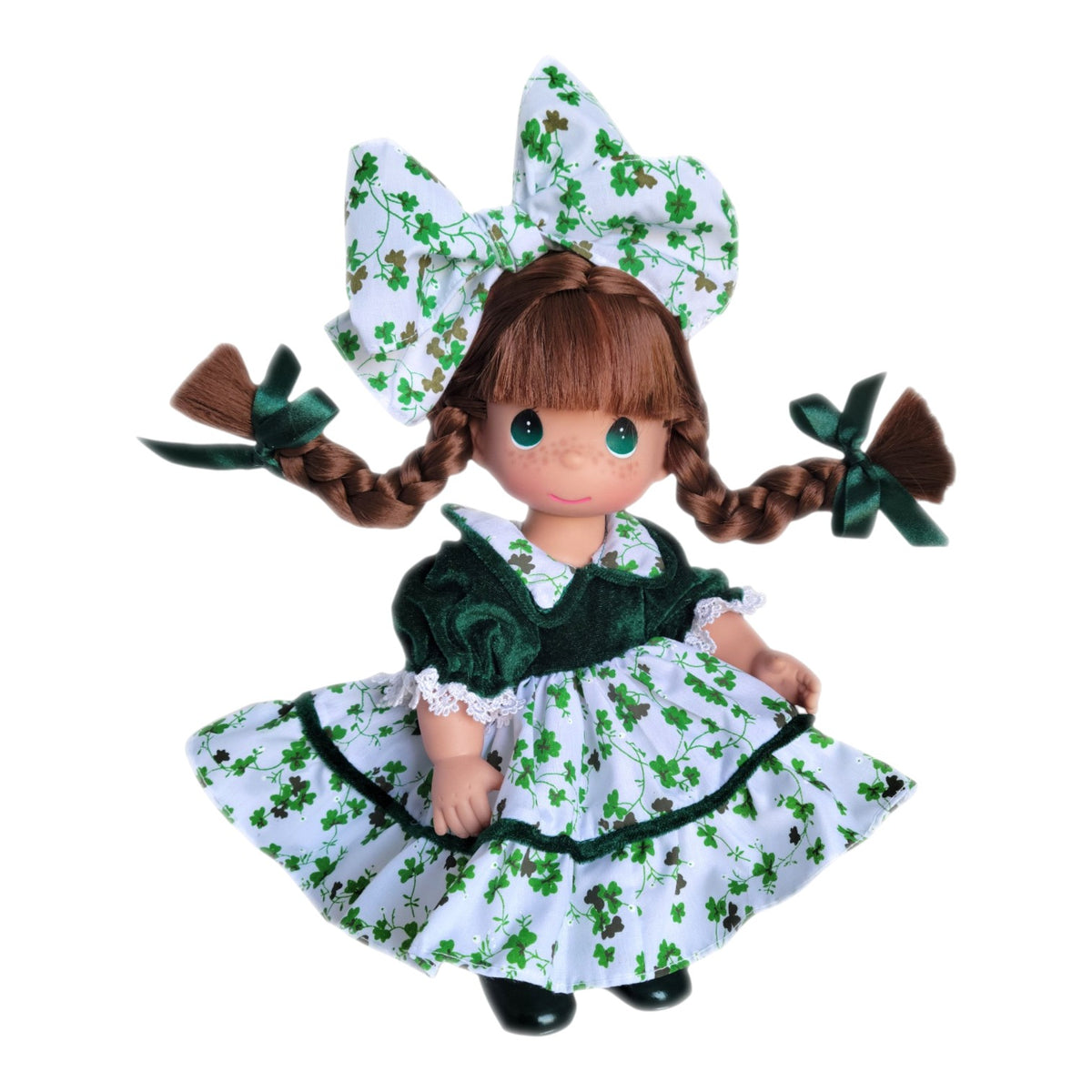 The Doll Maker 12-inch brunette doll wearing a green velvet dress with a white shamrock print and matching hair bow.