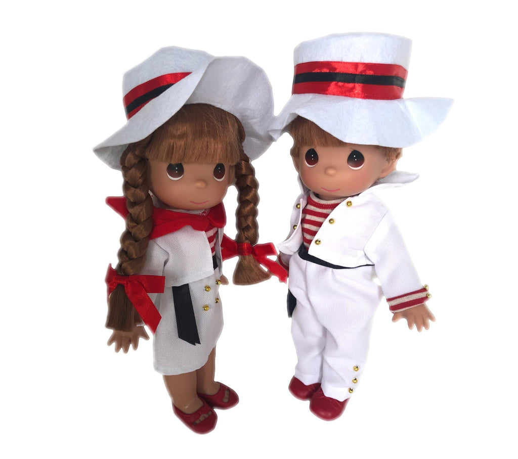 The Doll Maker 12-inch Italian doll set featuring a girl with braids and a boy in matching white outfits and hats.