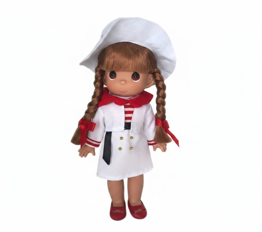 The Doll Maker 12-inch Italian doll wearing a white coat, red scarf, and matching hat with braided brown hair.