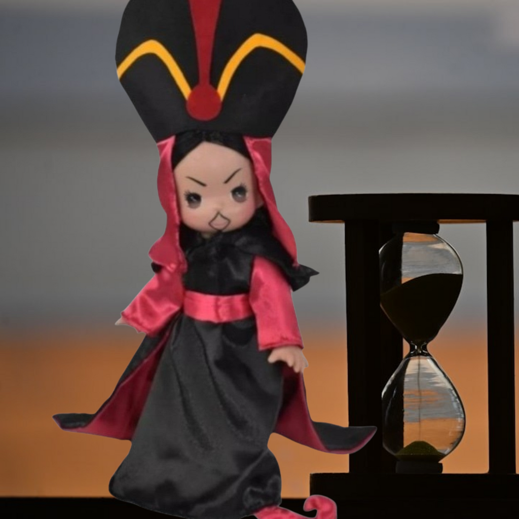The Doll Maker 12-inch Jafar vinyl doll wearing signature black and red robes with a tall headpiece next to hourglass.