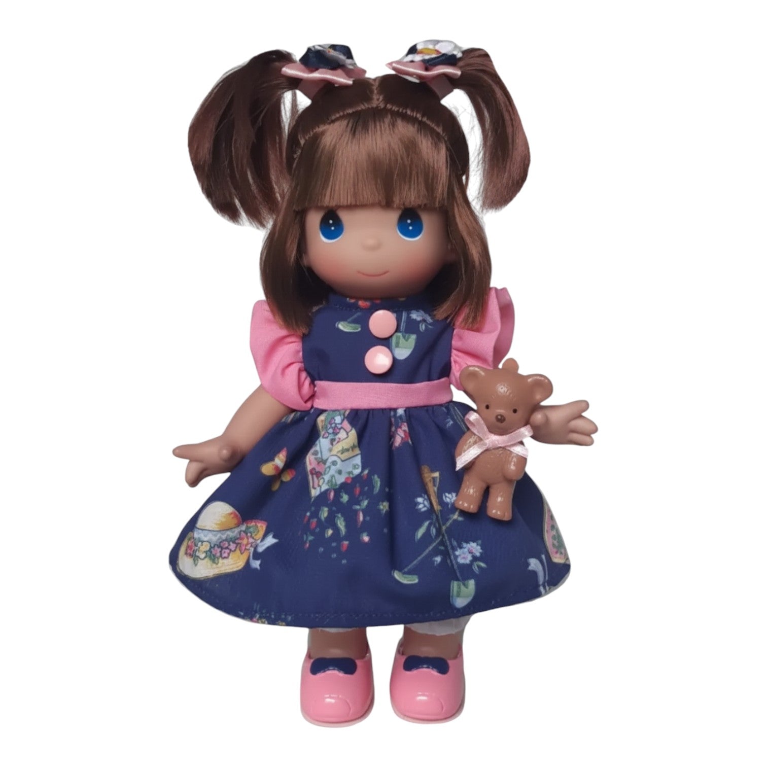 The Doll Maker Kimberly 9-inch collector doll with brown pigtails, blue eyes, and a navy floral dress with pink shoes.
