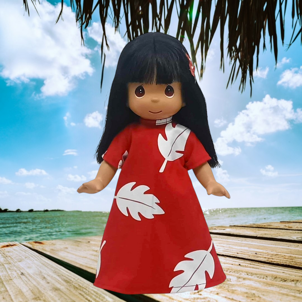 The Doll Maker 12-inch Lilo vinyl doll wearing a red dress with white leaf print, standing on a wooden dock.