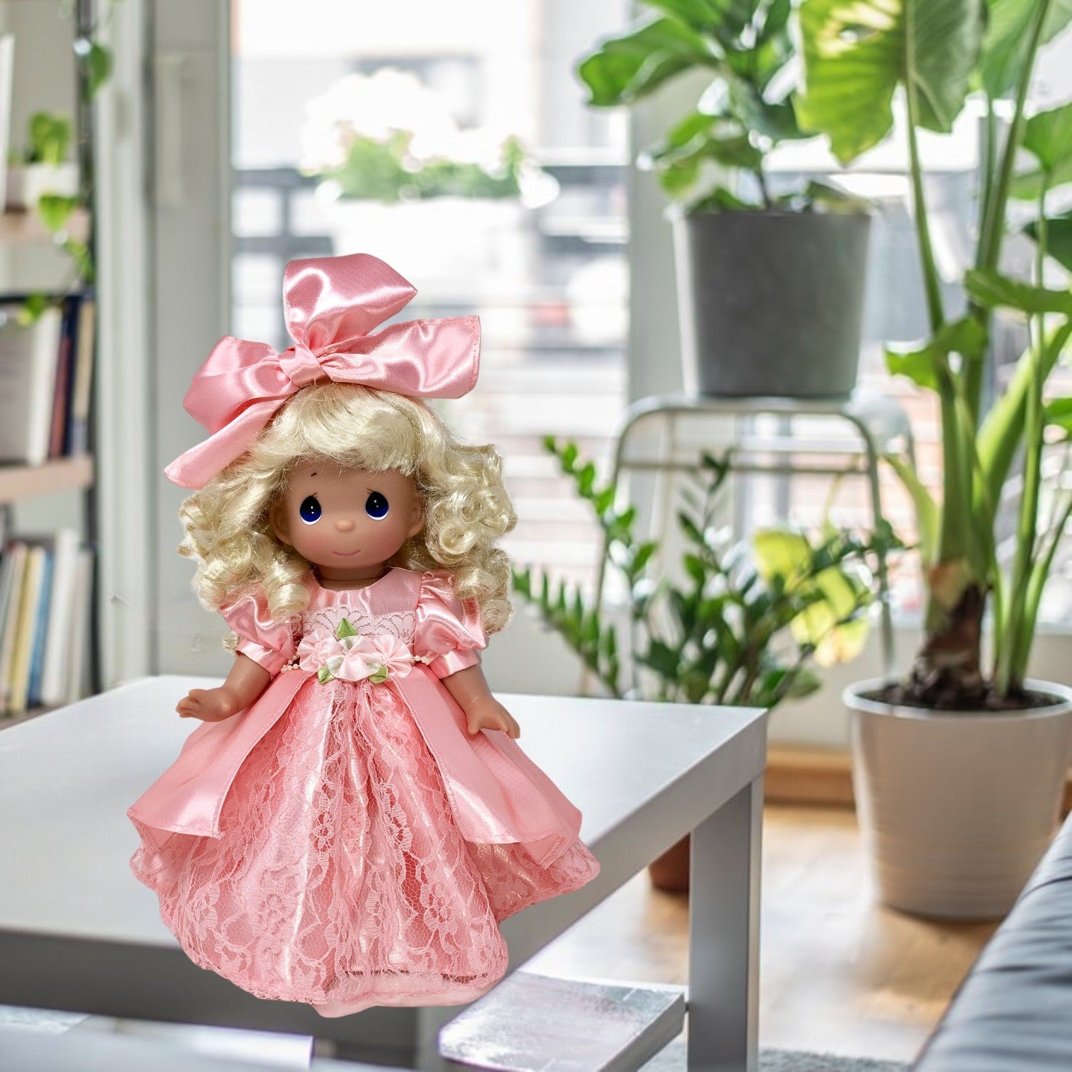 The Doll Maker Little Golden Girl of Mine 12-inch vinyl doll wearing a pink satin and lace dress with a large bow.