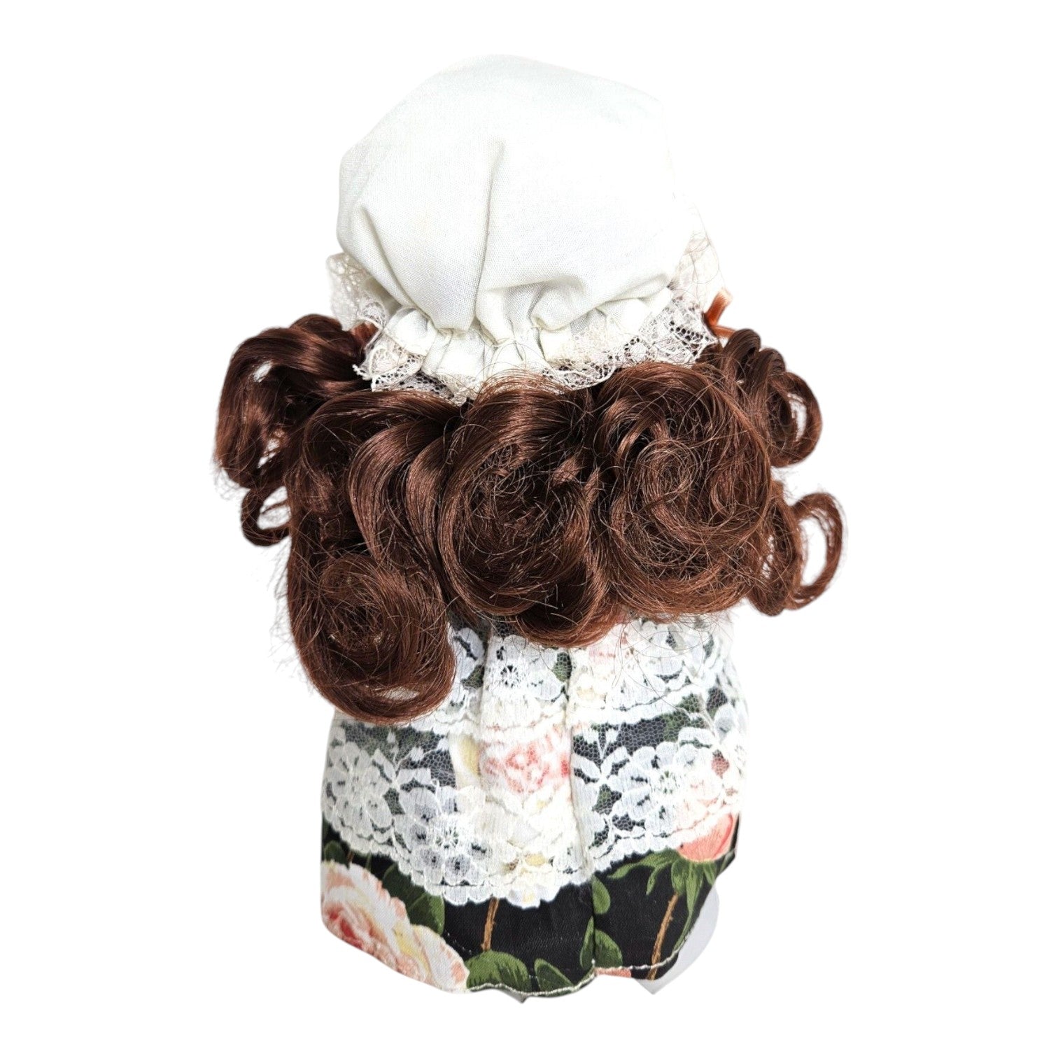 Back view of The Doll Maker Little Miss Muffet 7-inch vinyl doll with brunette curls and floral lace dress