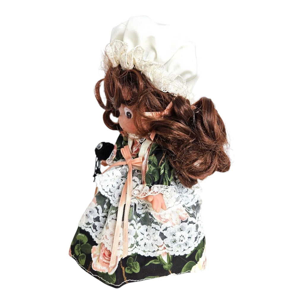 The Doll Maker Little Miss Muffet 7-inch vinyl doll wearing a floral dress with lace and a white bonnet holding a spider