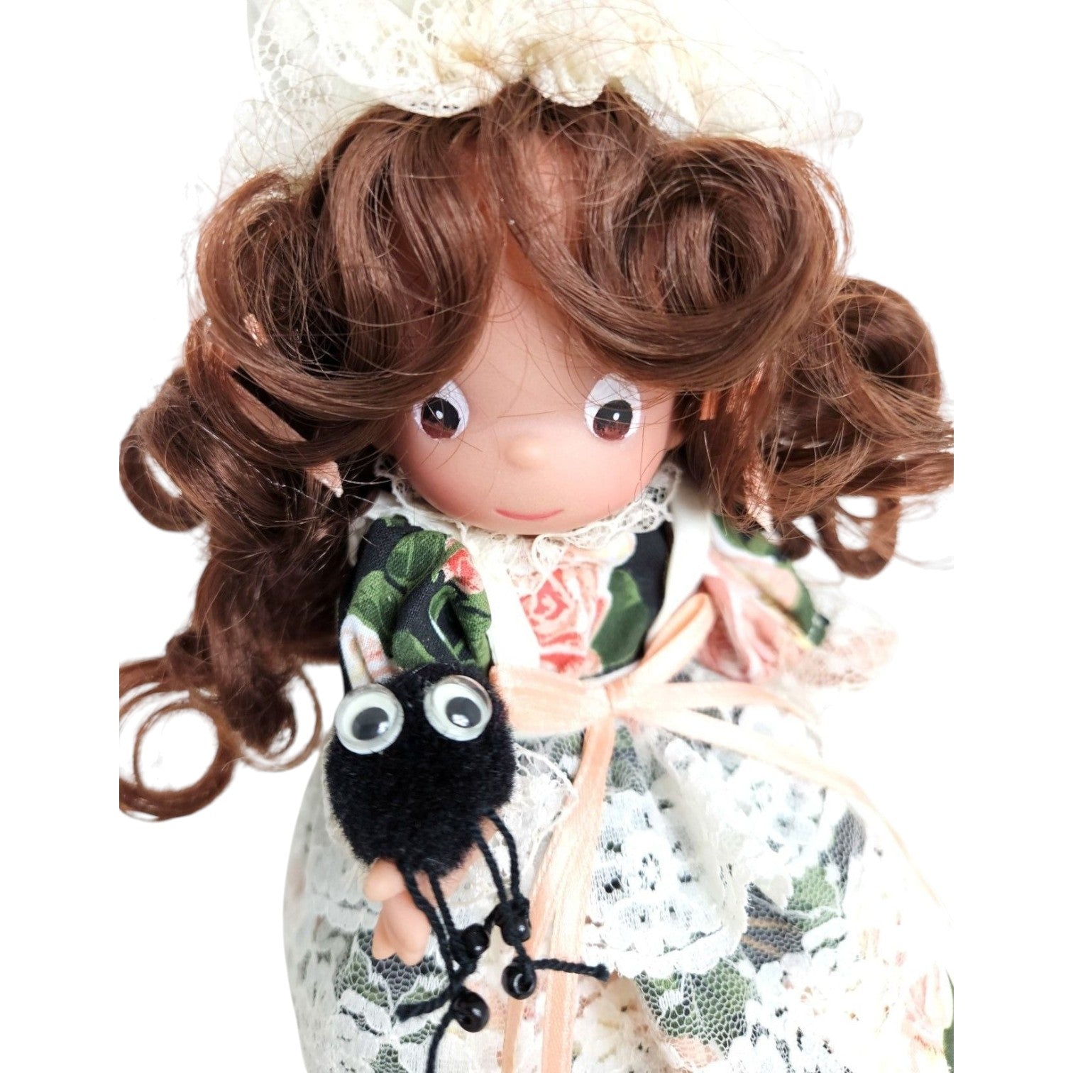 The Doll Maker Little Miss Muffet 7-inch vinyl doll with brunette hair, lace bonnet, and floral dress holding a spider