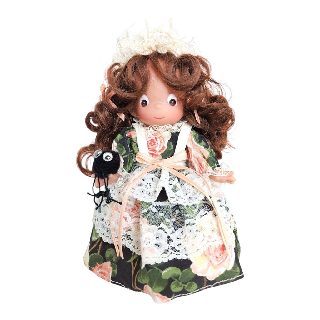 The Doll Maker Little Miss Muffet 7-inch vinyl doll with brunette curls, floral dress, lace apron, and toy spider.