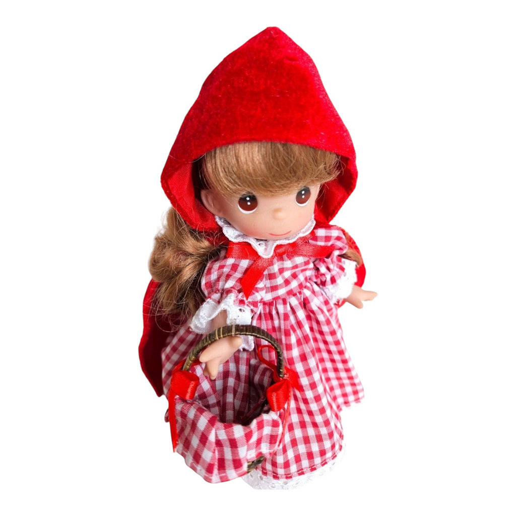 The Doll Maker 7-inch Little Red Riding Hood vinyl doll wearing a red hooded cape and a red and white gingham dress.