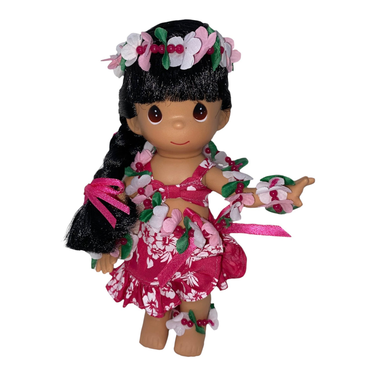 The Doll Maker 7-inch Lokelani Hawaiian doll wearing a pink floral hula outfit with a matching flower lei and crown.
