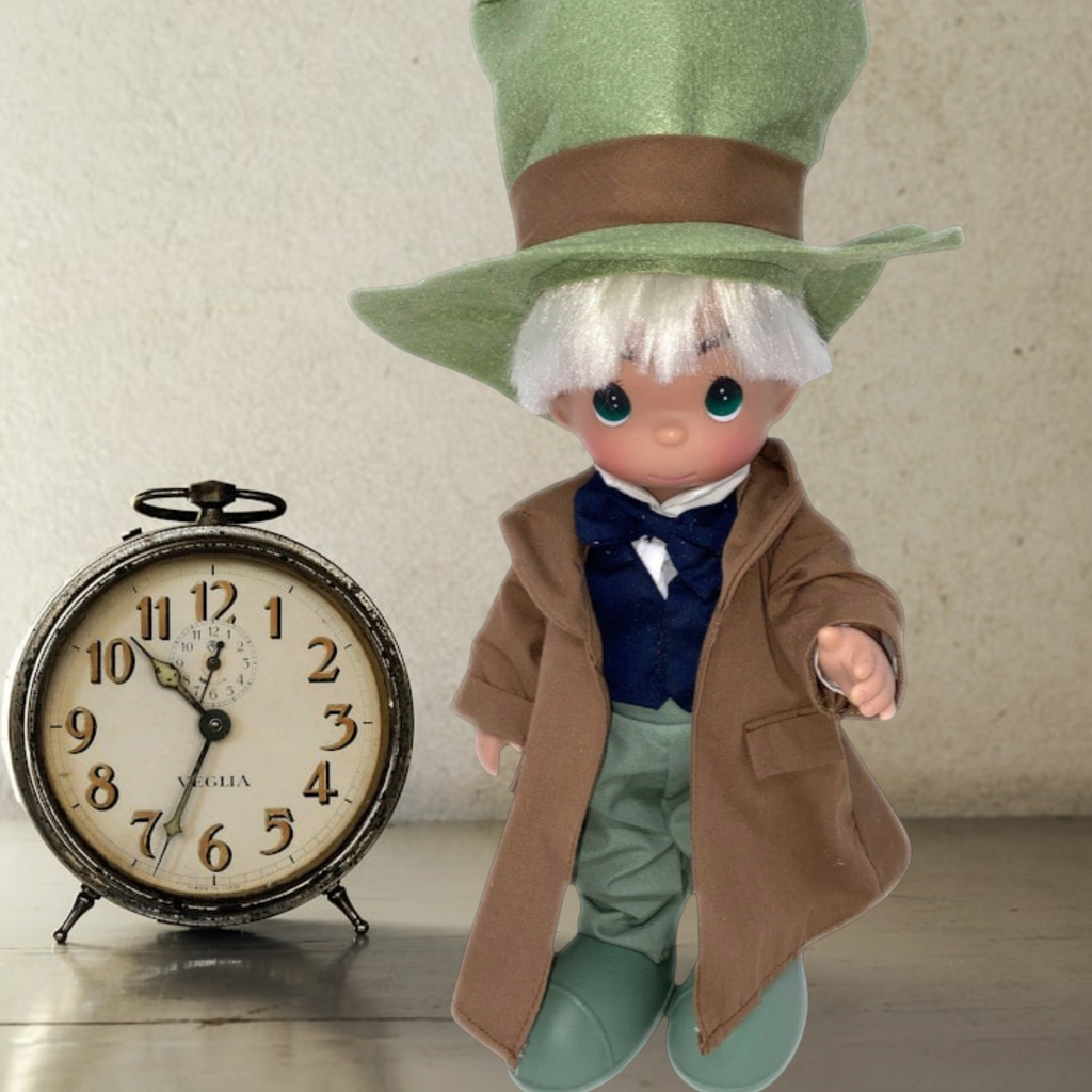 The Doll Maker 12-inch Mad Hatter vinyl doll wearing a large green top hat, brown coat, and blue vest.