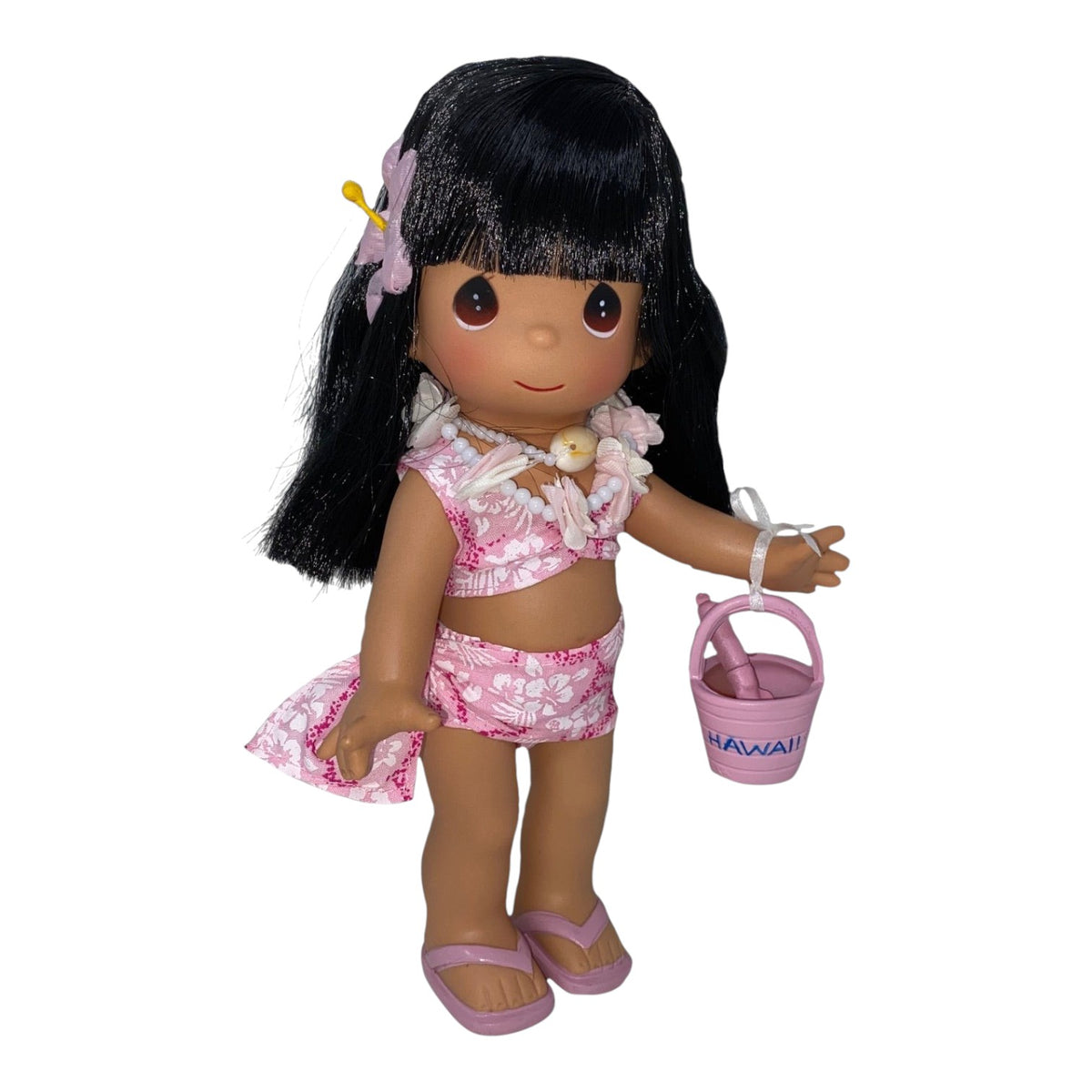 The Doll Maker Mahealani 9-inch Hawaiian doll with black hair, wearing a pink floral bikini and holding a small bucket.