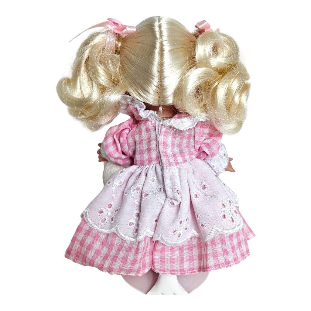 The Doll Maker Mary Had a Little Lamb 7-inch vinyl doll seen from the back wearing a pink gingham dress.