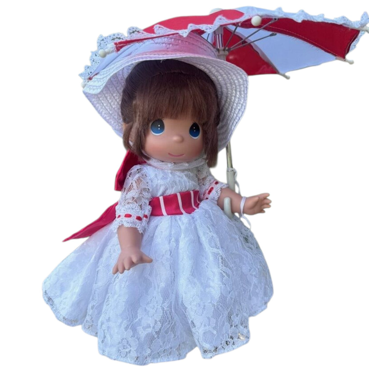 The Doll Maker 12-inch Mary Poppins doll wearing a white lace dress with red ribbons and a matching parasol.