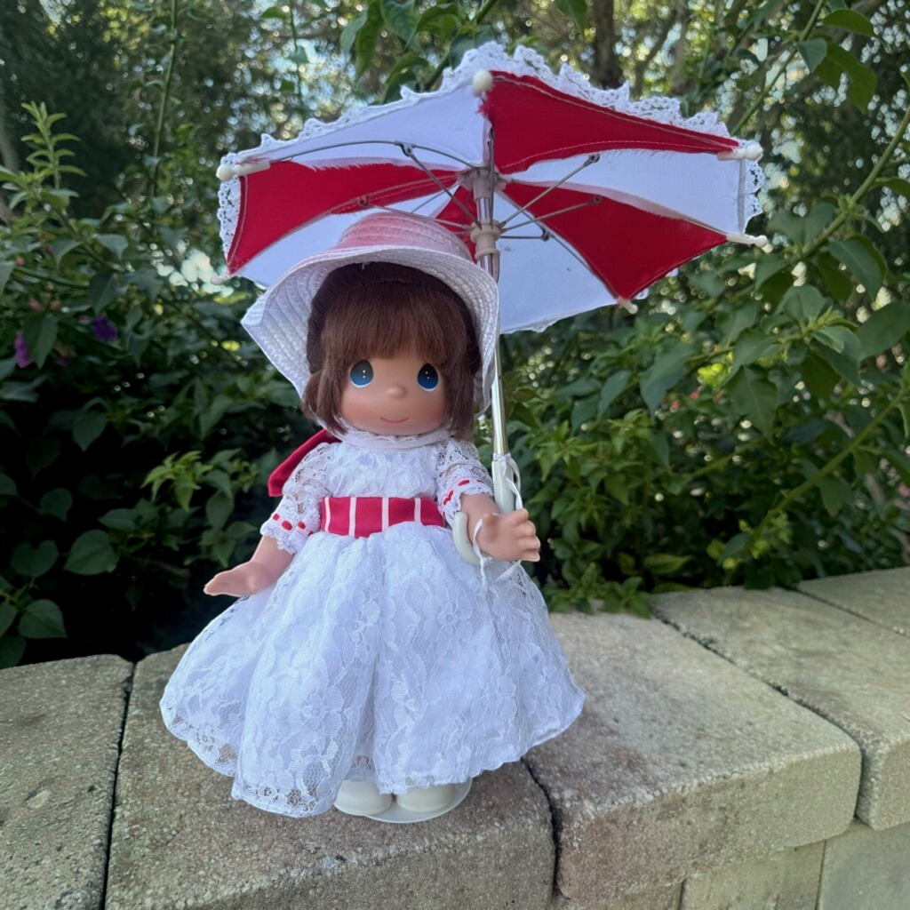 The Doll Maker 12-inch Mary Poppins doll in a white lace dress with a red ribbon and matching red and white parasol.