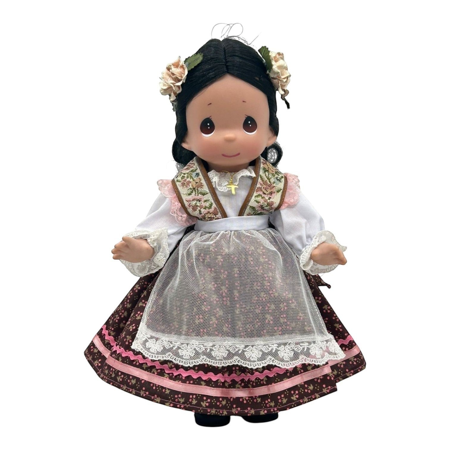 The Doll Maker 12-inch Mexico vinyl doll wearing a traditional floral dress with lace apron and flower hair accessories.