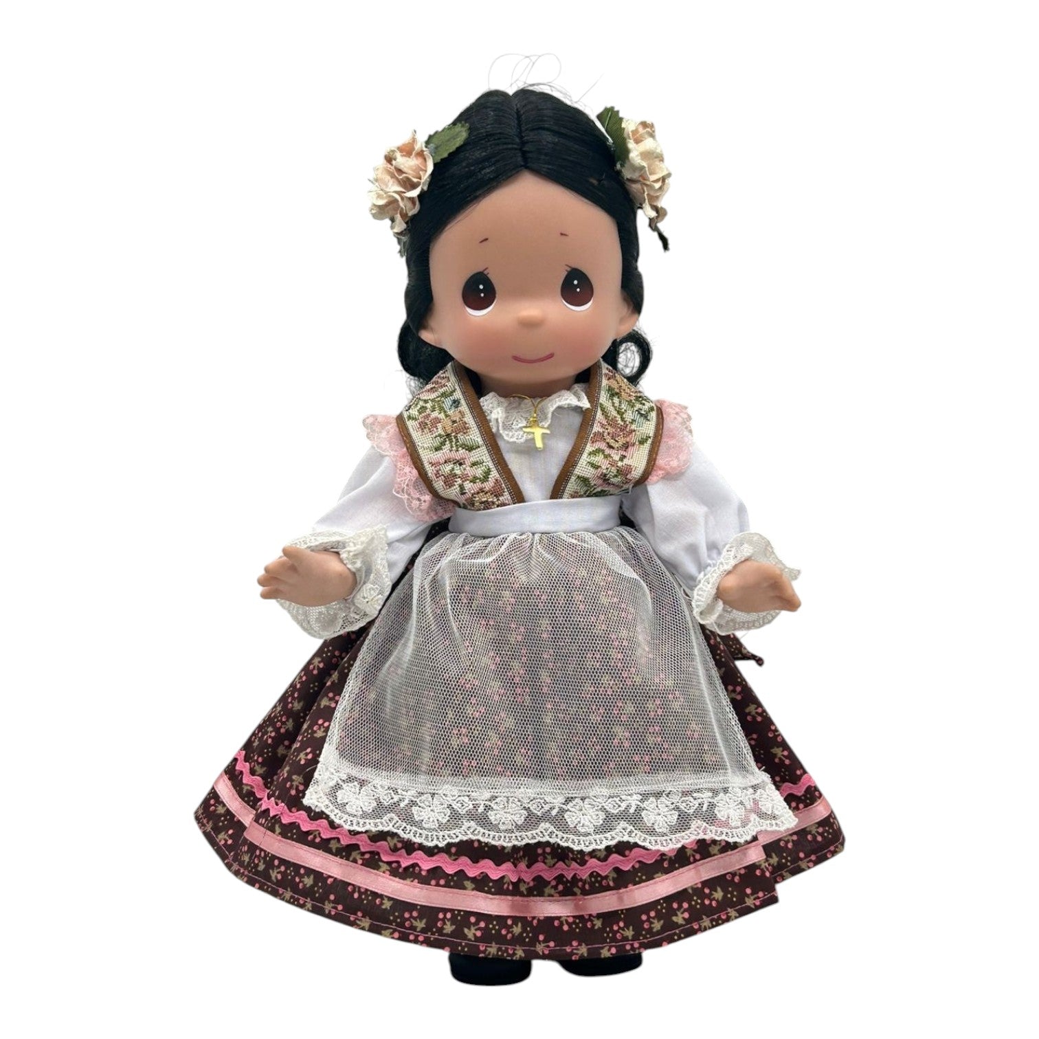 The Doll Maker 12-inch Mexico doll wearing a traditional floral dress with lace apron and flower hair accessories.