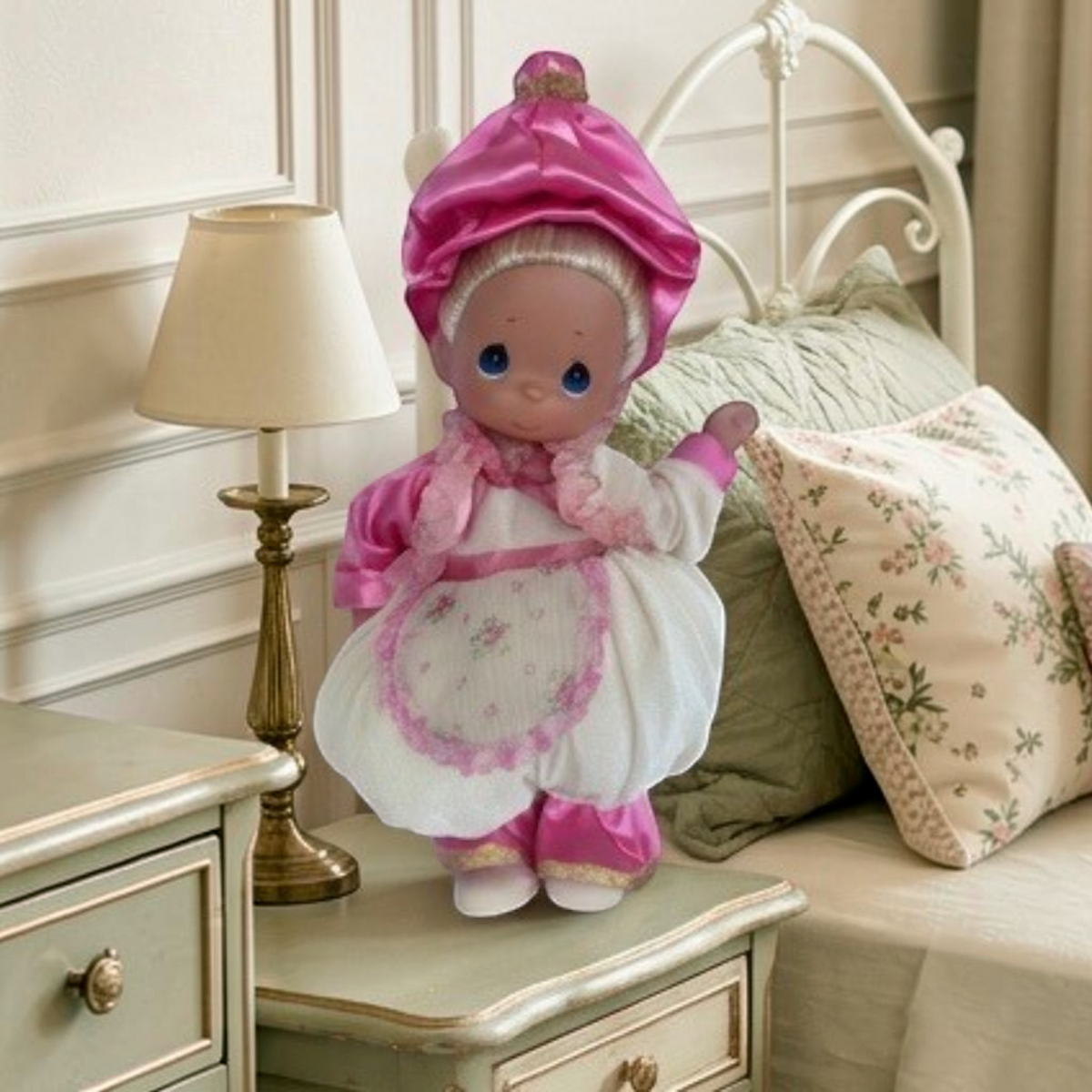 The Doll Maker 12-inch Mrs. Potts collectible doll wearing a pink satin bonnet and white floral apron dress.