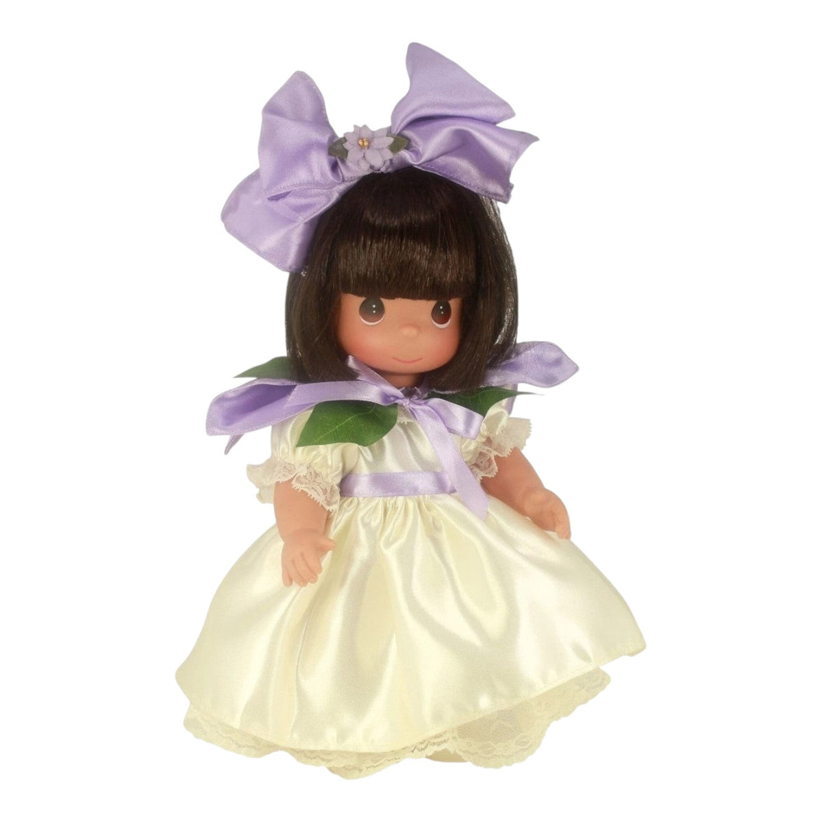 The Doll Maker Bouquet of Friendship Orchid 12-inch vinyl doll wearing a cream dress with a large purple hair bow.