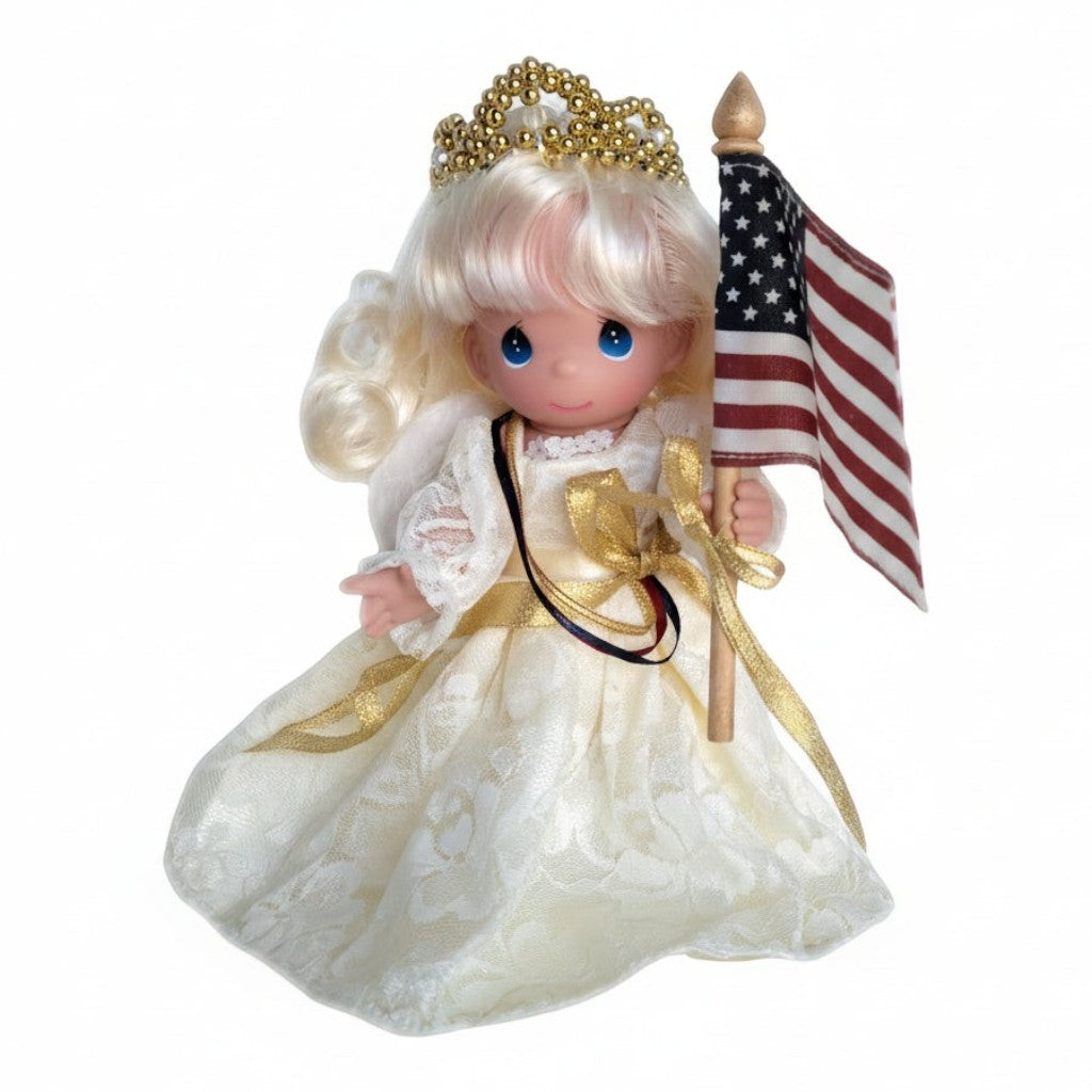 The Doll Maker Sweet Liberty 9-inch patriotic angel doll wearing a lace gown, gold crown, and holding an American flag