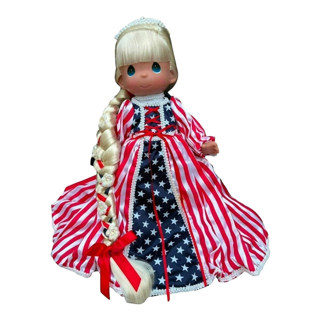 The Doll Maker 12-inch Patriotic Rapunzel doll with long blonde braid and red, white, and blue star-striped gown.