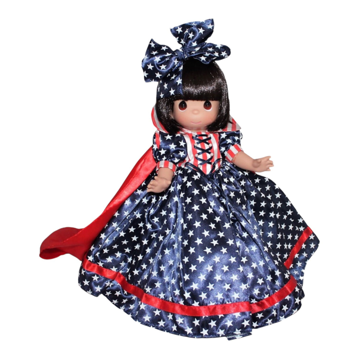 The Doll Maker 12-inch Snow White doll wearing a patriotic red, white, and blue star-patterned dress with a cape.