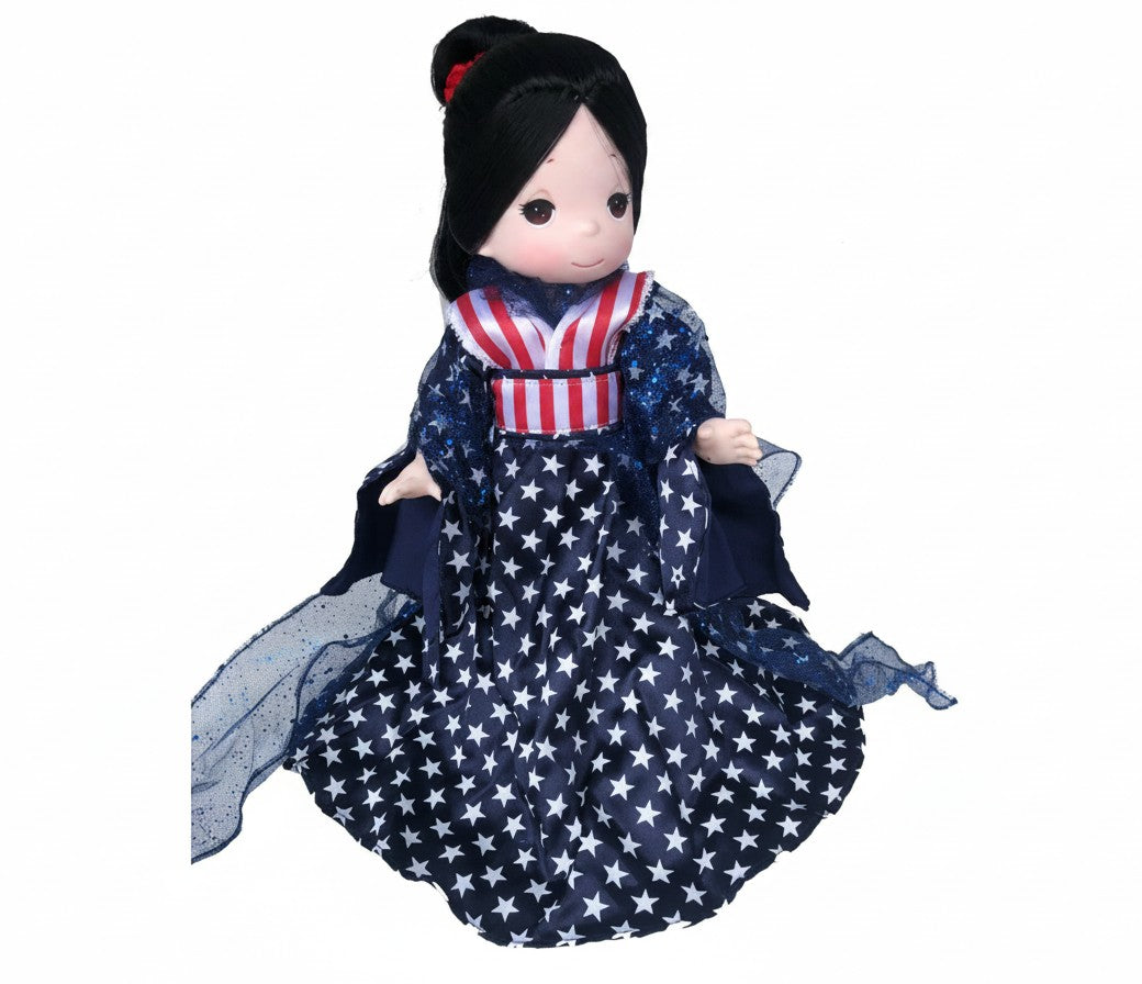 The Doll Maker Patriotic Warrior 12-inch doll with black hair, wearing a star-patterned dress and red-white-blue sash.