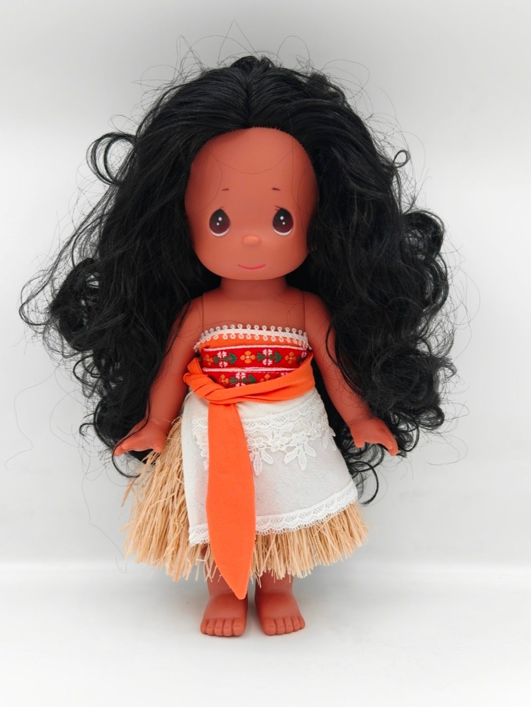 The Doll Maker 12-inch Polynesian Princess doll with long black hair, traditional island attire, and grass skirt.