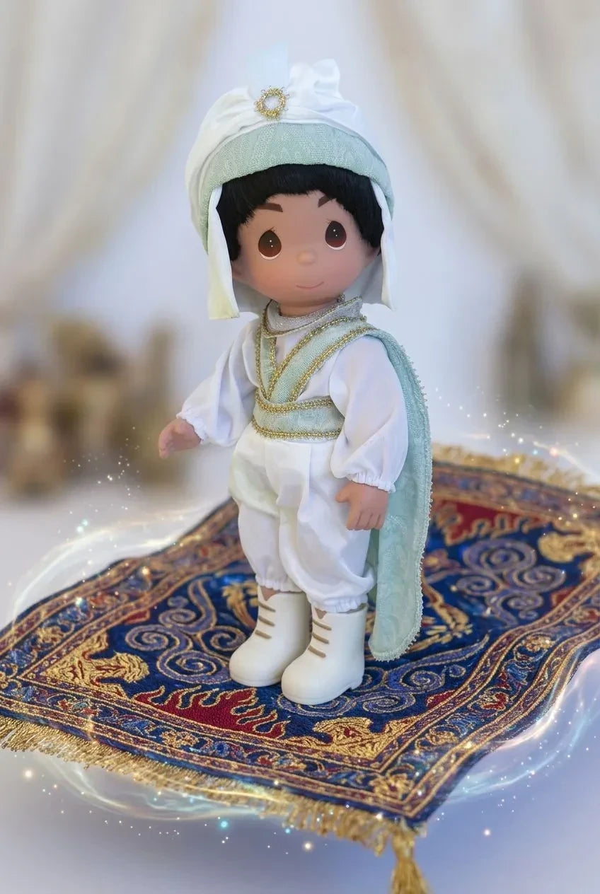 The Doll Maker 12-inch Prince Ali vinyl doll from Aladdin wearing a white and mint green outfit on a magic carpet