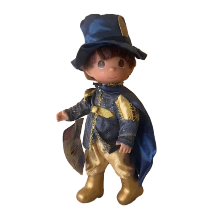 The Doll Maker 12-inch Prince Phillip doll in blue and gold 50th anniversary royal attire with a matching hat and cape.