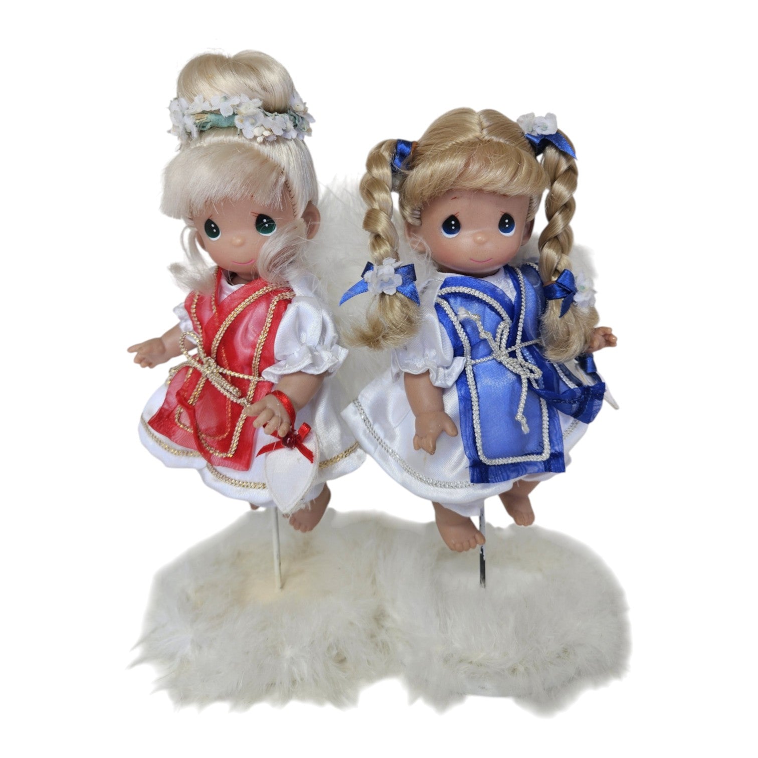 The Doll Maker 7-inch prototype angel dolls with blonde hair, wearing red and blue dresses on white fluffy stands.