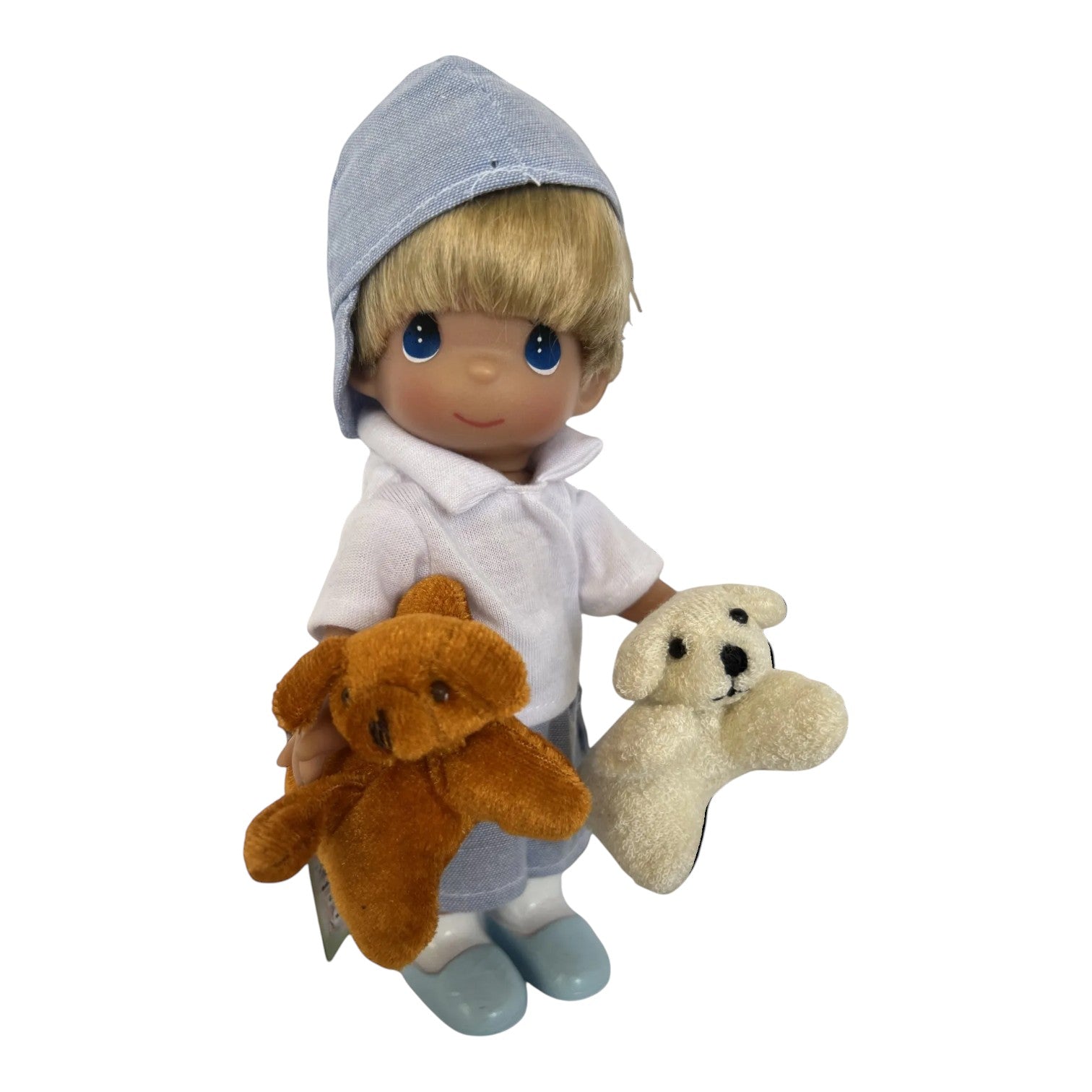 The Doll Maker 7-inch Puppy Dog Tails vinyl doll featuring a blonde boy in a blue cap holding two plush puppies.