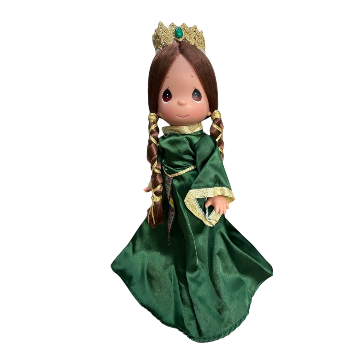 The Doll Maker Queen Elinor 12-inch collectible doll in an emerald green gown with a gold crown, outdoors.