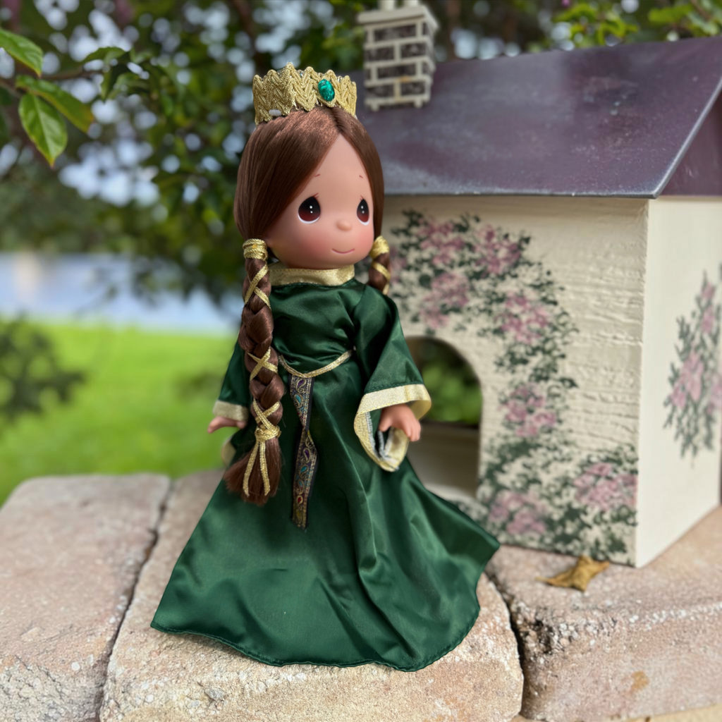The Doll Maker Queen Elinor 12-inch collectible doll in an emerald green gown with gold trim and a matching crown.