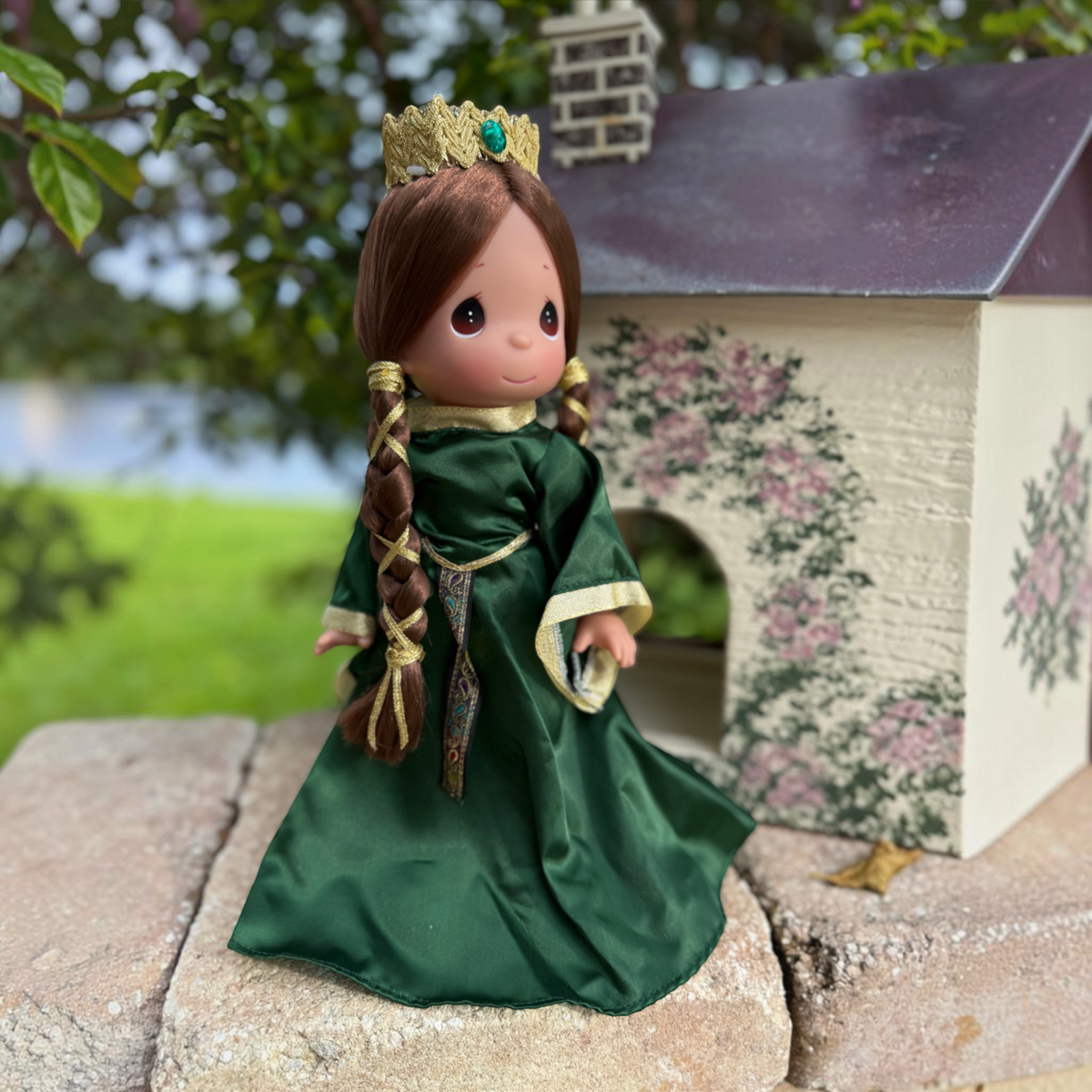 The Doll Maker Queen Elinor 12-inch collectible doll in an emerald green gown with gold trim and a matching crown.