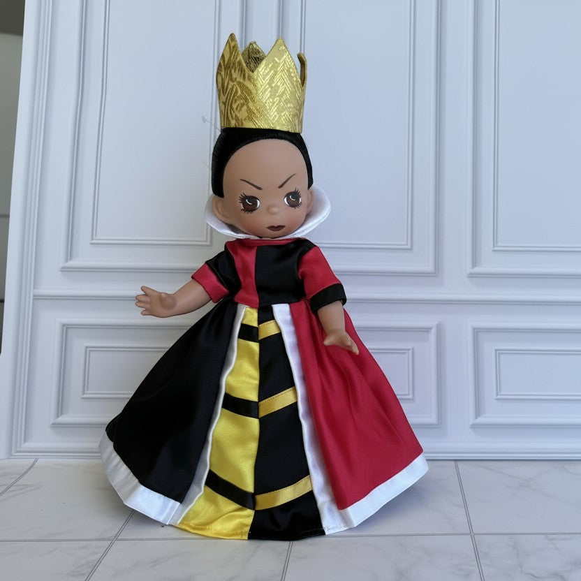 The Doll Maker 12-inch Queen of Hearts doll wearing a gold crown and a red, black, and yellow satin gown.
