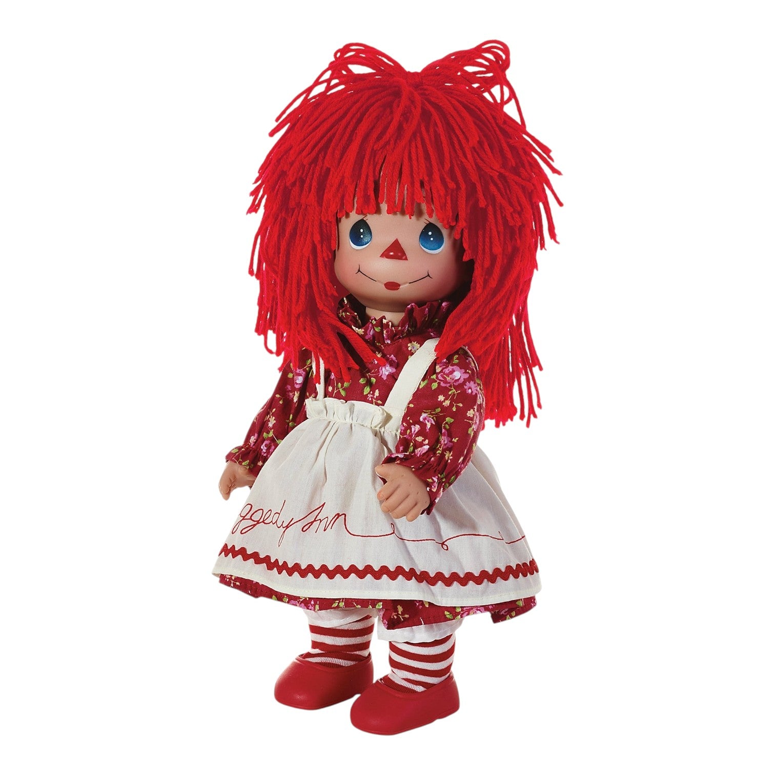 The Doll Maker 12-inch Raggedy Ann vinyl doll with red yarn hair, floral dress, and white pinafore.